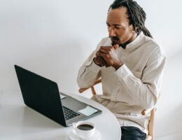 serious black man working on laptop in light room