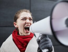 a woman in red scarf holding a megaphone